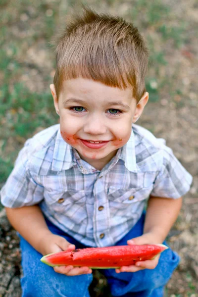 Kaukasiska liten pojke äter en skiva vattenmelon — Stockfoto