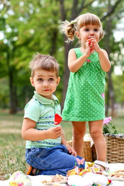 Kaukázusi kisfiú és a lány a édesség evés — Stock Fotó