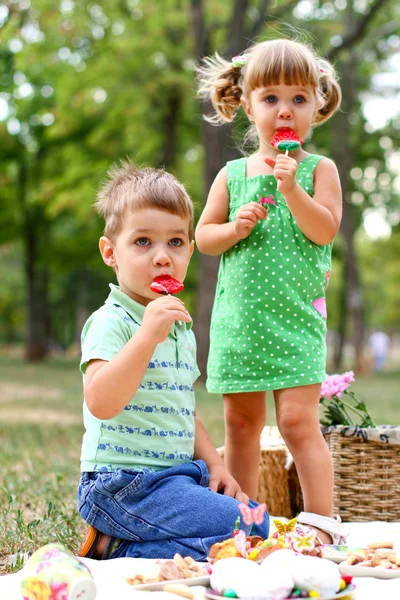 Caucasian little boy and girl eating sweets — Stock Photo, Image