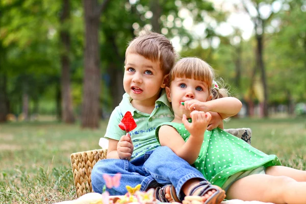 Beyaz küçük erkek ve kız tatlılar yemek — Stok fotoğraf