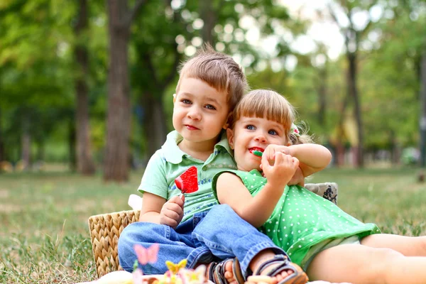 Caucasian little boy and girl eating sweets — Stock Photo, Image