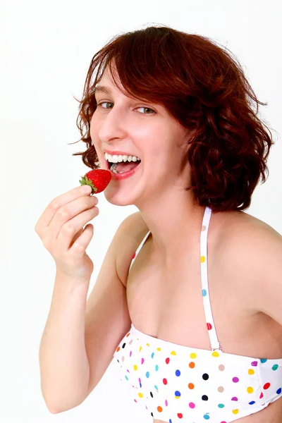 Jovem mulher comendo um morango — Fotografia de Stock