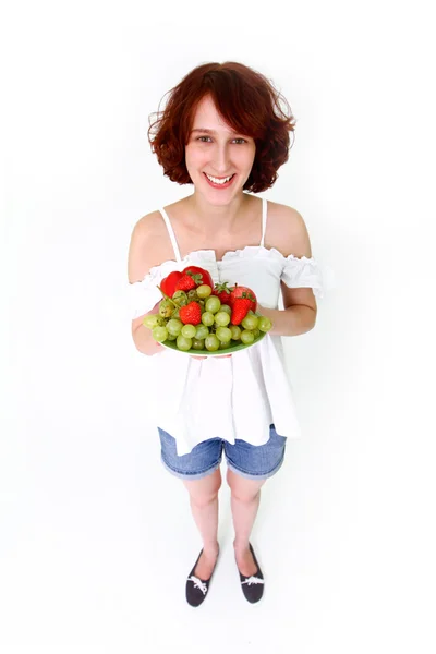 Mujer joven con frutas en un plato — Foto de Stock