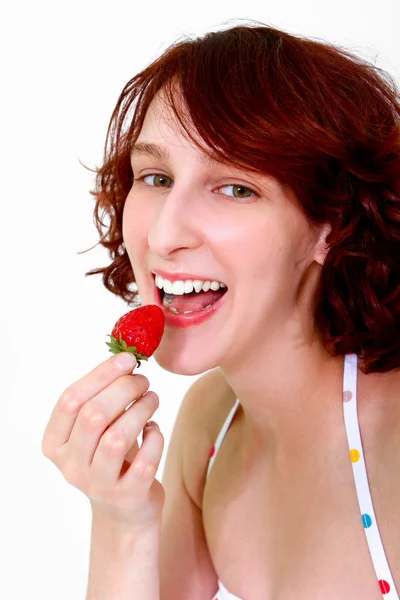 Jovem mulher comendo um morango — Fotografia de Stock