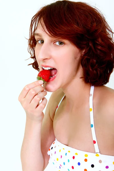 Jovem mulher comendo um morango — Fotografia de Stock