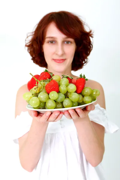 Mujer joven con frutas en un plato —  Fotos de Stock