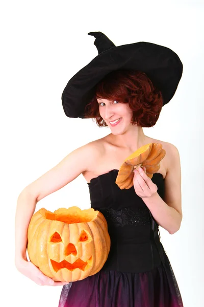 Halloween witch with a pumpkin in her hands isolated over white — Stock Photo, Image