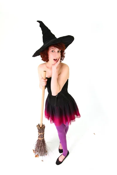 Sorpresa strega di Halloween con una scopa isolata su un dorso bianco — Foto Stock