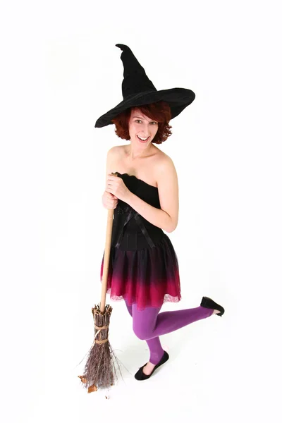 Улыбающаяся ведьма Хэллоуина с метлой, изолированной над белой бэкгро — стоковое фото