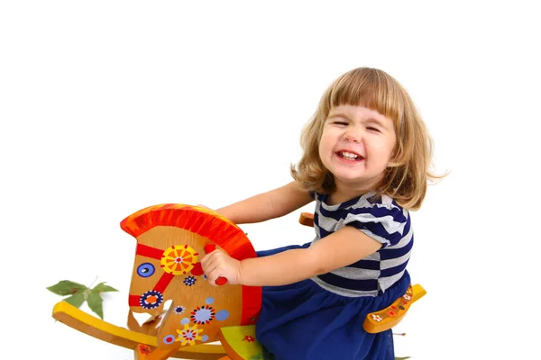 A little girl riding on toy horse isolated on white background — Stock Photo, Image