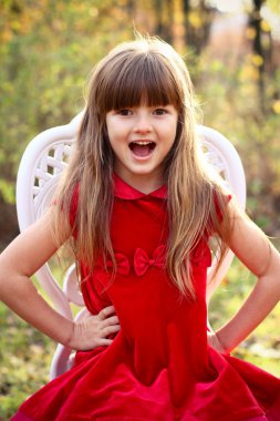 sevimli küçük kız bir sandalyede sonbahar orman