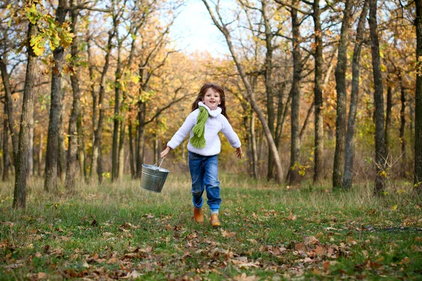 Sweet girl running with a bucket outdoors — Stock Photo, Image