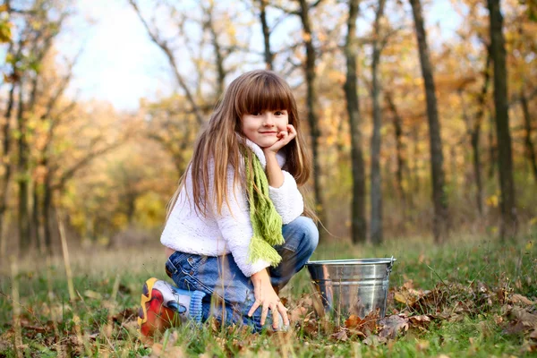 Liten flicka med en Plåthink i skogen höst utomhus — Stockfoto