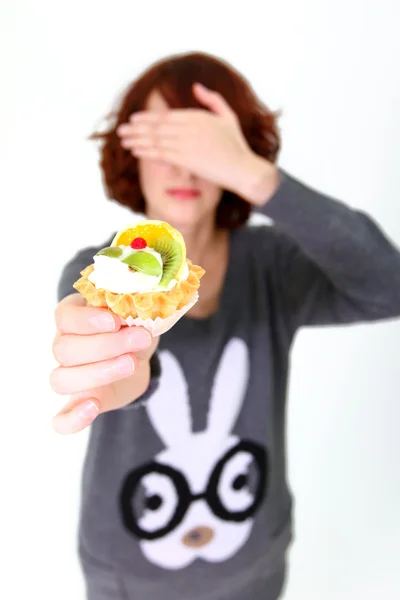 Girl holding a cake and shutting her eyes isolated on white back — Stock Photo, Image