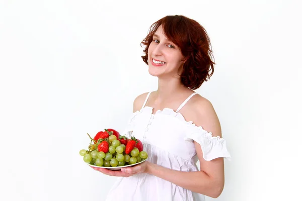 Mujer joven con frutas en un plato — Foto de Stock