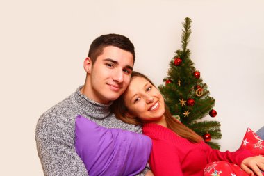 yastıklar ve izole bir Noel ağacı ile kız ve erkek gülümseyen