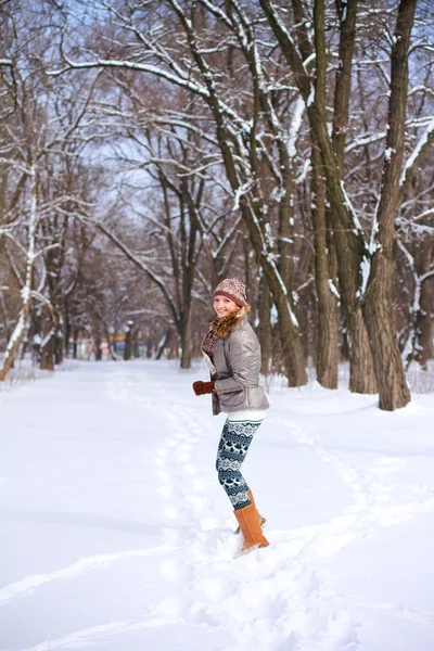 ブロンドの女の子は冬公園の屋外の雪で遊んでの笑みを浮かべてください。 — ストック写真