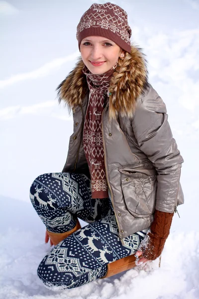 Sorrindo jovem mulher de inverno na neve ao ar livre — Fotografia de Stock