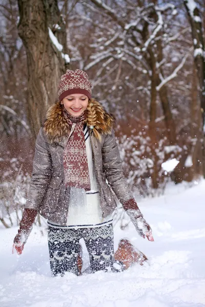 Menina sorridente brincando com neve ao ar livre — Fotografia de Stock