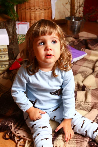 Baby sitting on the plaid near the Christmas tree — Stock Photo, Image