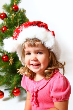 Yeni yıl veya Noel ağacı üzerinde beyaz izole yakın gülen bebek