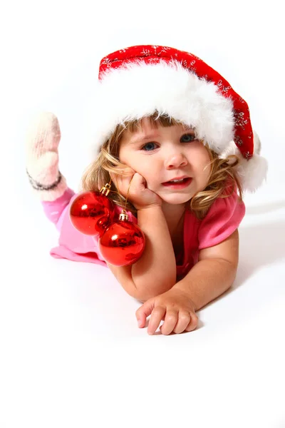 Zoete baby met een hoed van santa claus en ballen geïsoleerd op wit — Stockfoto