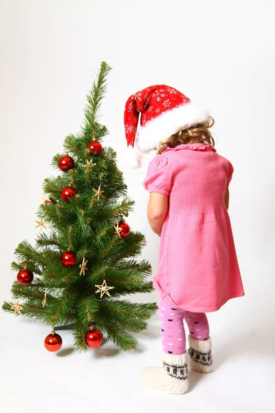 小女孩被隔绝在白色背景上的新的一年树附近 — 图库照片