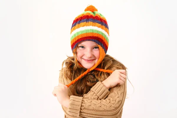 Cheerful little girl in colorful sweater and hat isolated on whi — Stock Photo, Image