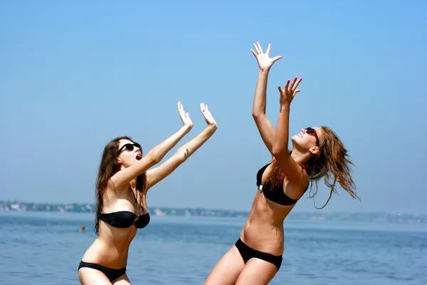 Happy young women playing ball at the beach — Stock Photo, Image