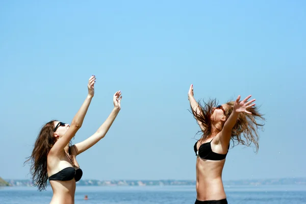 Gelukkig jonge vrouwen spelen bal op het strand — Stockfoto