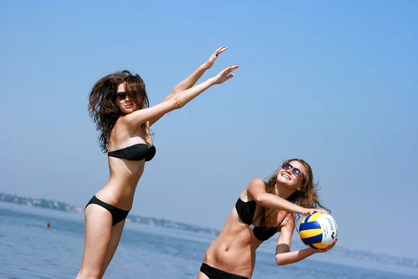 Happy young women playing ball at the beach — Stock Photo, Image
