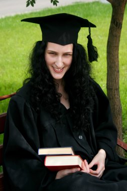 Beyaz öğrenci bankta oturan gülümsüyor