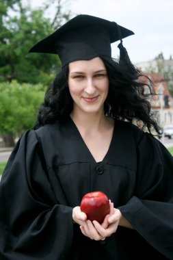 Beyaz öğrenci kız elbise ile elma