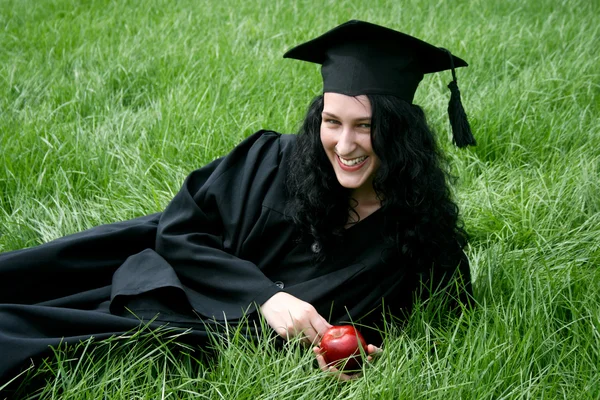 Junge lächelnde kaukasische Studentin liegt auf dem Gras — Stockfoto