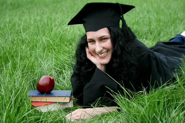 Jonge lachende Kaukasische student opleggen op het gras — Stockfoto