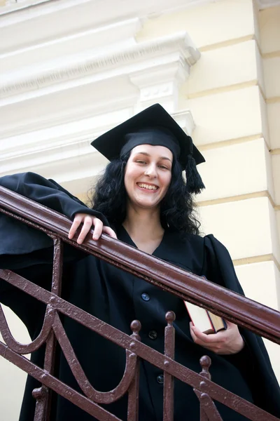 Young laughing student in gown near the university — Stock Photo, Image
