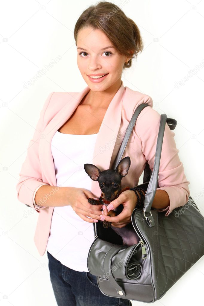 Smiling young woman with Chihuahua in a bag isolated on white ba