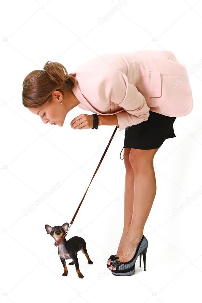 Pretty young woman with a black Chihuahua on a leash isolated on