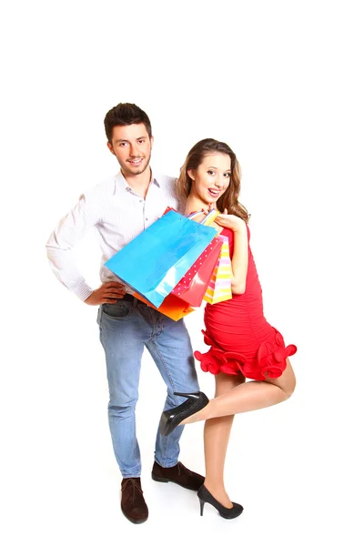 Jonge gelukkige paar met boodschappentassen geïsoleerd op witte CHTERGRO — Stockfoto