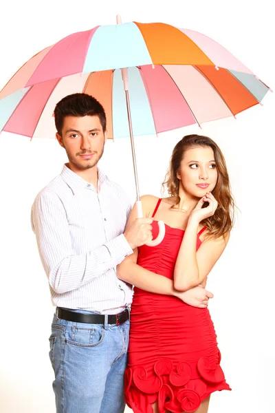 Romantisches junges Paar mit einem bunten Regenschirm isoliert auf weiß — Stockfoto