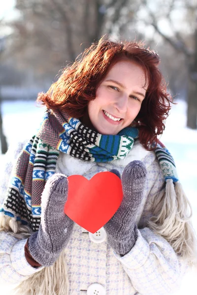 Sweet winter romantic girl holding a red heart outdoors — Stock Photo, Image