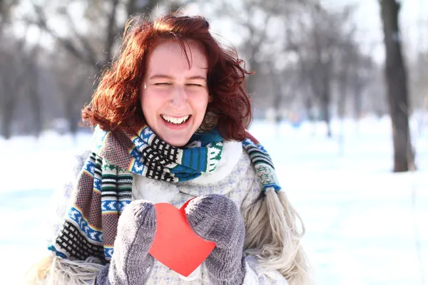 Ragazza ridente che tiene il cuore rosso in Winter Park — Foto Stock