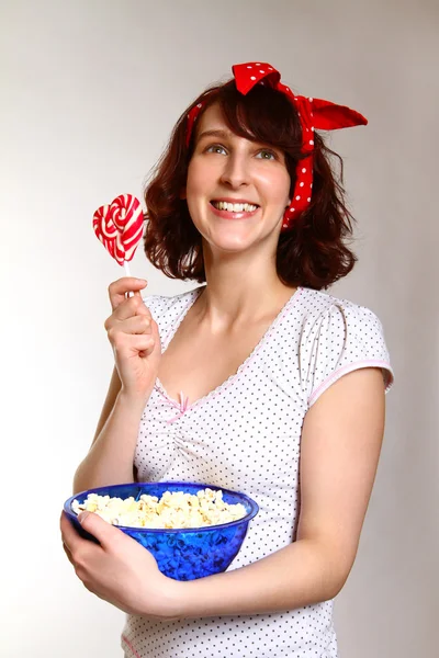 Uśmiechnięta młoda kobieta z popcornem i lollipopg na białym tle na gra — Zdjęcie stockowe