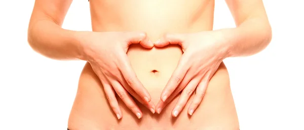 Woman with hands on belly forming heart isolated — Stock Photo, Image