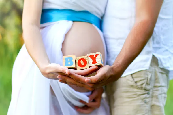 Close-up of the belly of a pregnant woman and of her husband hol Stock Image
