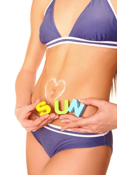 Gros plan de l'estomac de la femme avec lotion solaire coeur et mot soleil — Photo