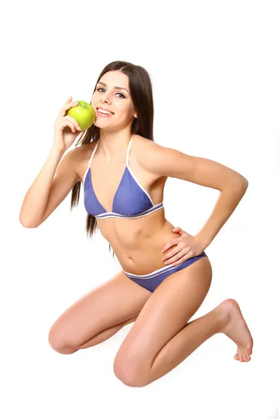 Sexy young woman in a swimsuit posing with an apple on a white b — Stock Photo, Image