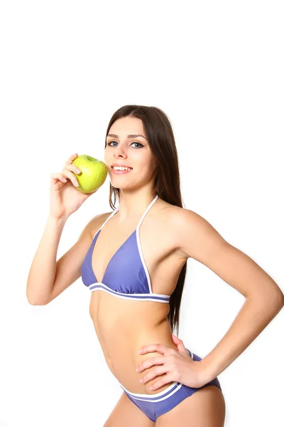 Mujer joven de pie en bikini con manzana sobre fondo blanco — Foto de Stock