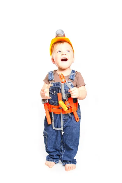 Enfant dans un casque orange avec des outils sur fond blanc — Photo