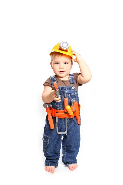 Mignon petit garçon dans un casque orange et des outils sur un dos blanc — Photo